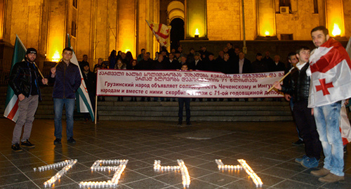 Поминальные свечи между грузинскими и чеченскими флагами. Фото Беслана Кмузова для "Кавказского узла"