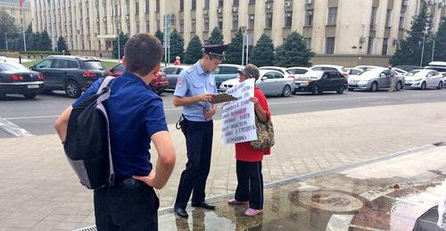 Сотрудник полиции общается с участницей одиночного пикета дольщиков ЖК "Анит-сити". Краснодар, 7 августа 2017 г. Фото Светланы Кравченко для "Кавказского узла" Сотрудник полиции общается с участницей одиночного пикета дольщиков ЖК "Анит-сити". Краснодар, 7 августа 2017 г. Фото Светланы Кравченко для "Кавказского узла"