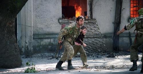 Ополченец выводит ребенка из горящего здания в Сухуми. 1993 год. Фото: Андрей Соловьев, RFE/RL Ополченец выводит ребенка из горящего здания в Сухуми. 1993 год. Фото: Андрей Соловьев, RFE/RL