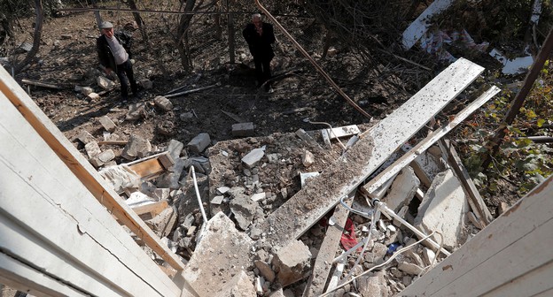 Мужчины стоят рядом с развалинами дома, разрушенного обстрелом, в городе Мартуни, 14 октября 2020 года. Фото: REUTERS/Stringer Мужчины стоят рядом с развалинами дома, разрушенного обстрелом, в городе Мартуни, 14 октября 2020 года. Фото: REUTERS/Stringer