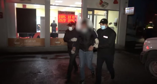 Полицейские ведут задержанного по подозрению в нападении на офис быстрых займов в Тбилиси и захвате заложников, 20 ноября 2020 года. Стоп-кадр из видео на Youtube-канале МВД Грузии https://www.youtube.com/watch?v=FOa5Oip1Nqo. Полицейские ведут задержанного по подозрению в нападении на офис быстрых займов в Тбилиси и захвате заложников, 20 ноября 2020 года. Стоп-кадр из видео на Youtube-канале МВД Грузии https://www.youtube.com/watch?v=FOa5Oip1Nqo.