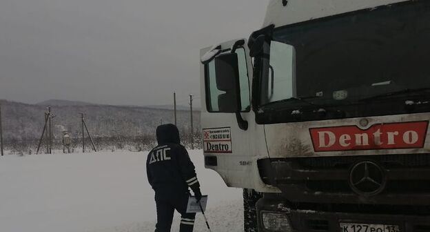 Сотрудник ДПС у большегрузного автомобиля в снегопад. Фото УГИБДД ГУ МВД России Сотрудник ДПС у большегрузного автомобиля в снегопад. Фото УГИБДД ГУ МВД России