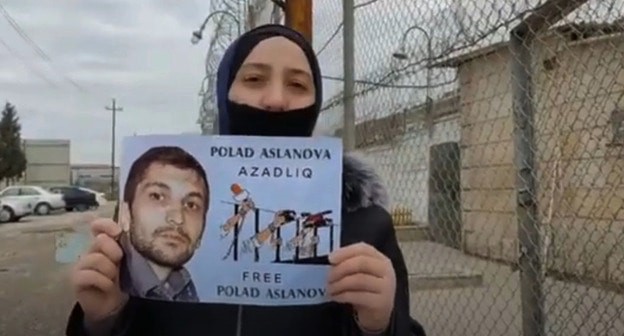 Супруга Полада Асланова с его портретом. Скриншот видео " Gülmirə Aslanova" https://www.youtube.com/watch?v=BdN3Yz3PP08 Супруга Полада Асланова с его портретом. Скриншот видео " Gülmirə Aslanova" https://www.youtube.com/watch?v=BdN3Yz3PP08