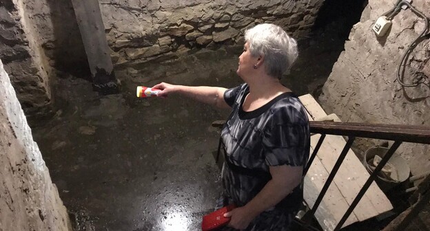 Жительница дома в Красном Сулине демонстрирует затопленный подвал. Фото Вячеслава Прудникова для "Кавказского узла" Жительница дома в Красном Сулине демонстрирует затопленный подвал. Фото Вячеслава Прудникова для "Кавказского узла"