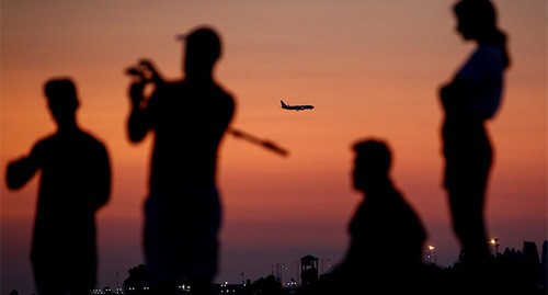 Туристы на берегу моря на фоне ночного города и пролетающего самолета. Сочи, май 2021 г. Фото: REUTERS/Maxim Shemetov Туристы на берегу моря на фоне ночного города и пролетающего самолета. Сочи, май 2021 г. Фото: REUTERS/Maxim Shemetov
