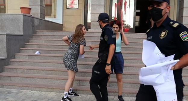 Полицейские отбирают плакаты у активисток. Баку, 4 августа 2021 года. Кадр видео Meydan TV www.youtube.com/watch?v=Sm9Wy_44uWs Полицейские отбирают плакаты у активисток. Баку, 4 августа 2021 года. Кадр видео Meydan TV www.youtube.com/watch?v=Sm9Wy_44uWs