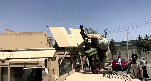 Боец Талибана на крыше бронетранспортера заряжает пушку возле аэропорта в Кабуле, Афганистан, 16 августа 2021 г. Фото: REUTERS TV/via Боец Талибана на крыше бронетранспортера заряжает пушку возле аэропорта в Кабуле, Афганистан, 16 августа 2021 г. Фото: REUTERS TV/via