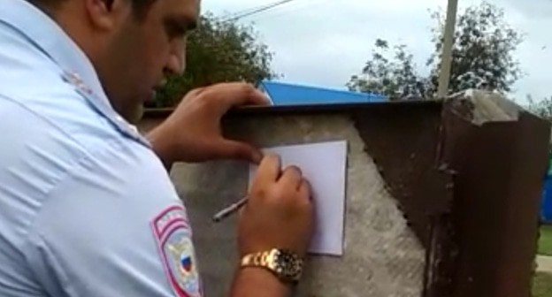 Сотрудник полиции составляет акт на пасеке. Фото Светланы Кравченко для "Кавказского узла" Сотрудник полиции составляет акт на пасеке. Фото Светланы Кравченко для "Кавказского узла"