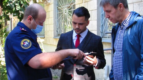 Евгению Кочегину (в центре) вручают повестку на допрос. 4 сентября 2021 года, Волгоград. Фото Вячеслава Ященко для "Кавказского узла"