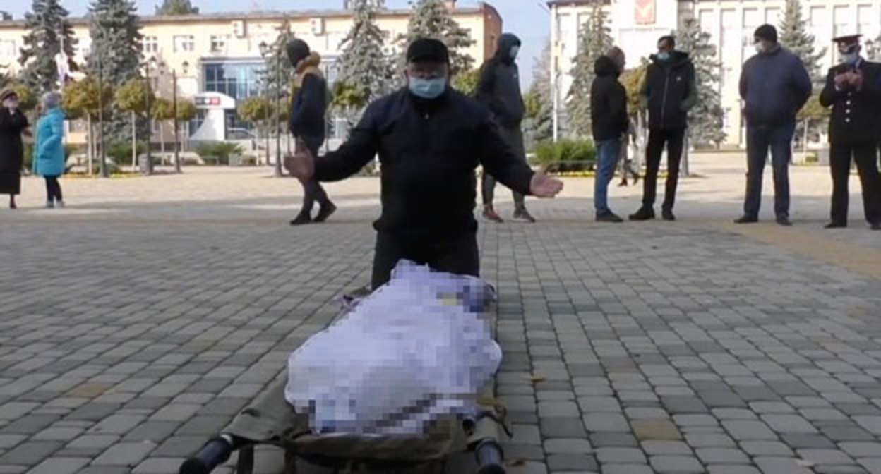 Акция ритуального агента возле здания администрации в Тимашевске. Скриншот видео https://www.gazeta.ru/social/news/2021/10/31/n_16780945.shtml Акция ритуального агента возле здания администрации в Тимашевске. Скриншот видео https://www.gazeta.ru/social/news/2021/10/31/n_16780945.shtml