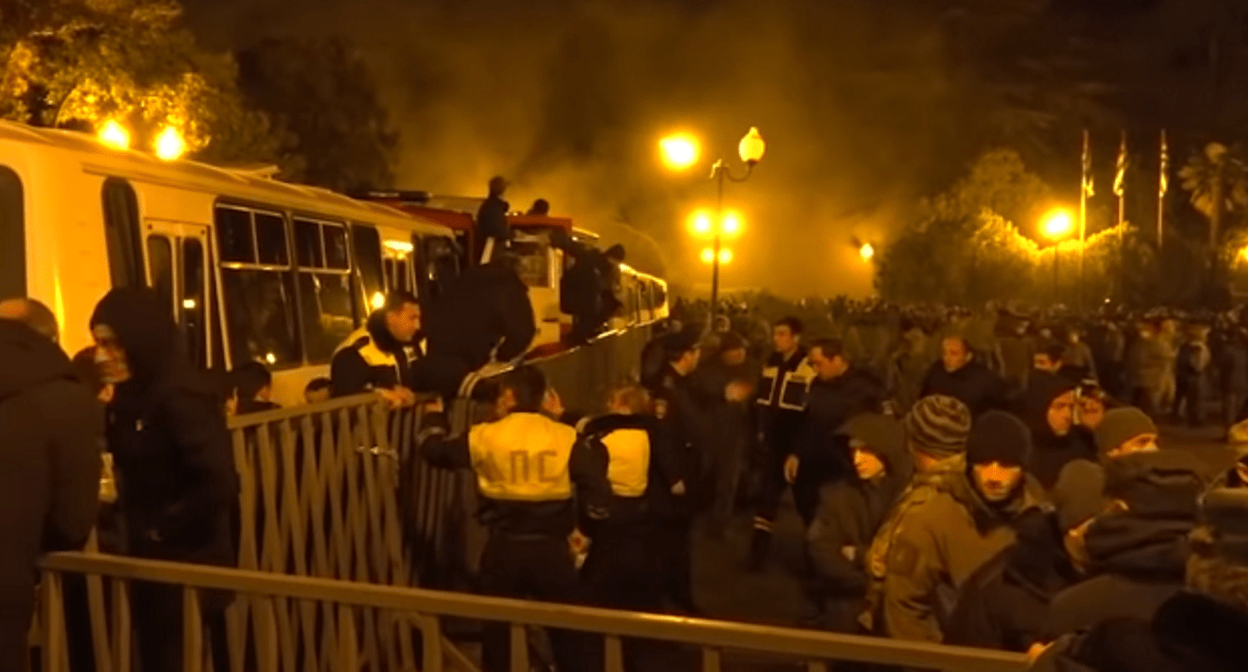 Противостояние митингующих и силовиков в Сухуме 21 декабря 2021 года. Кадр видеосюжета "Абаза-ТВ" www.youtube.com/watch?v=vE-UTOsYuSA Противостояние митингующих и силовиков в Сухуме 21 декабря 2021 года. Кадр видеосюжета "Абаза-ТВ" www.youtube.com/watch?v=vE-UTOsYuSA