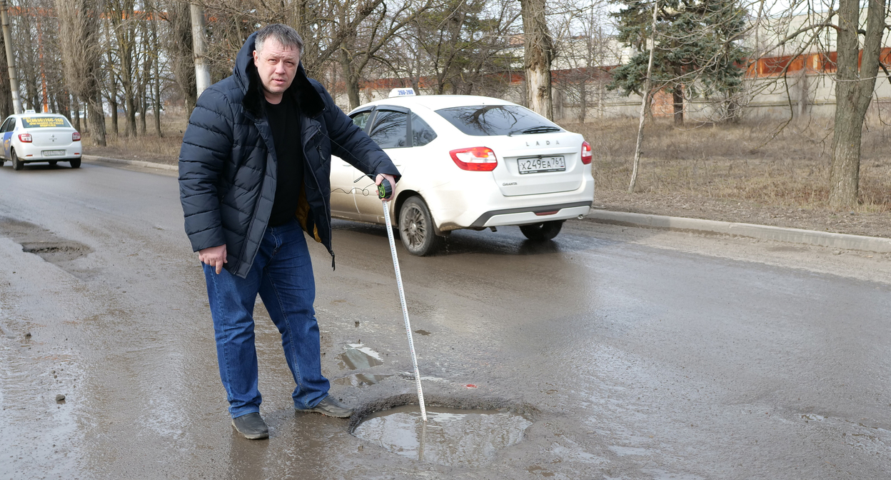 Роман Бабкин замеряет глубину ямы. Фото Сергея Снежина для "Кавказского узла". Роман Бабкин замеряет глубину ямы. Фото Сергея Снежина для "Кавказского узла".