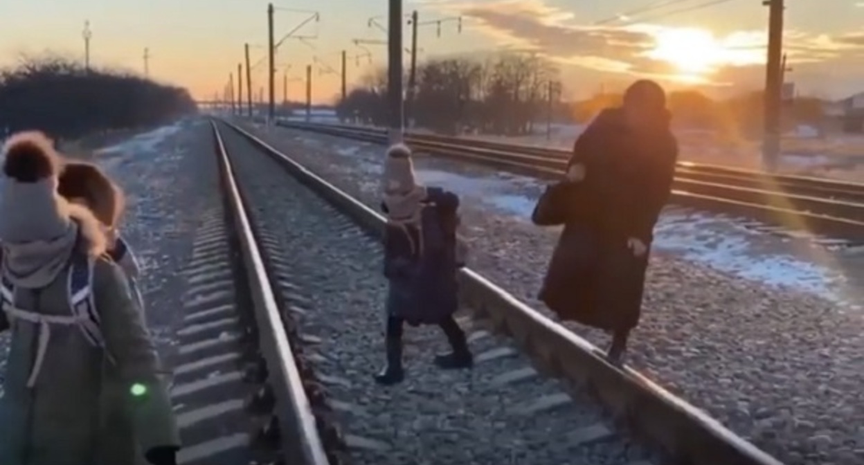 Жители Нового Сулака переходят через железнодорожные пути. Стопкадр из видео на странице https://www.instagram.com/p/CZbrO5VjEI_/ Жители Нового Сулака переходят через железнодорожные пути. Стопкадр из видео на странице https://www.instagram.com/p/CZbrO5VjEI_/