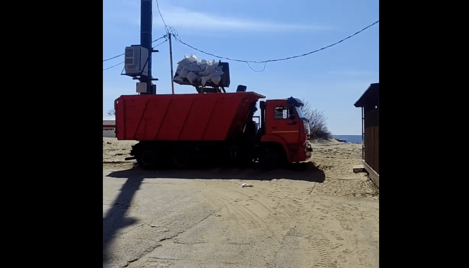 Мешки с песком грузят в самосвал. Скриншот фото из Telegram-канала Юрия Озаровского от 24.03.25, https://t.me/c/1482614470/1190360.
