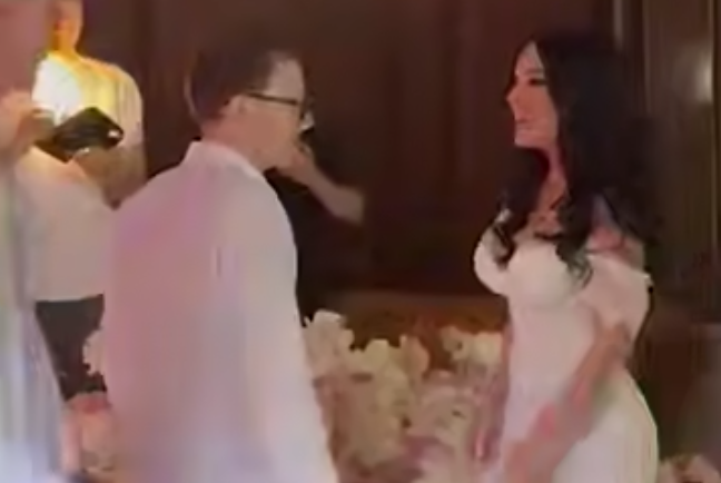 Альберт Каноков с девушкой на фоне букета. Стоп-кадр видео https://t.me/mash_gor/8107 от 12.06.25.