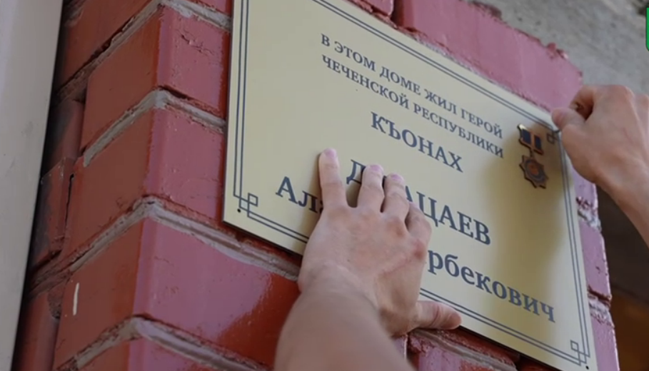 Установка памятной таблички на доме Алана Джацаева. Стоп-кадр видео из Telegram-канала Асламбека Ирасханова от 05.09.25, https://t.me/aslambekiraskhanov/1786.