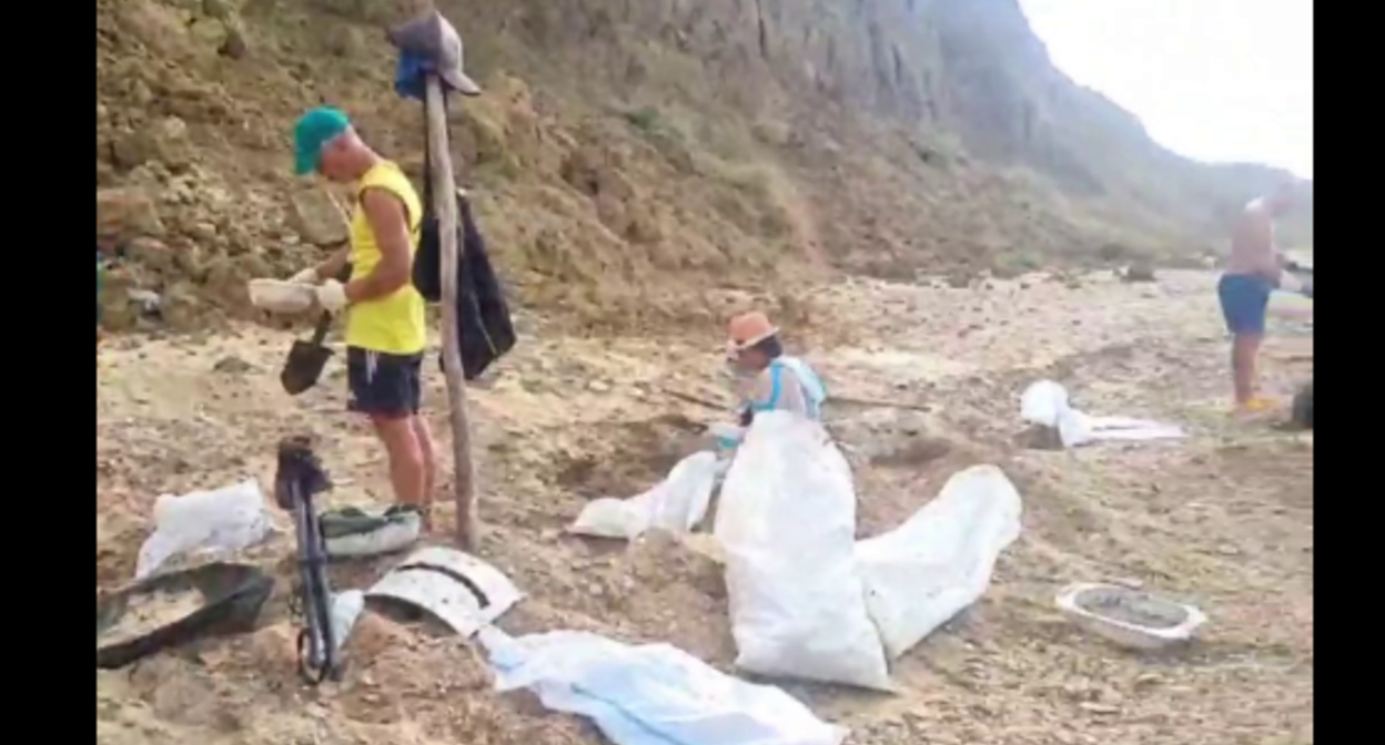 Волонтеры убирают мазут на мысе Тузла. Стоп-кадр видео штаба "Дельфины" от 09.09.25, https://t.me/shtab_delfin/1191