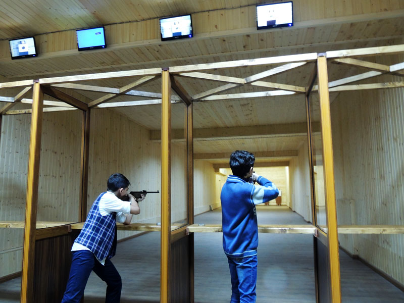 На мониторах вверху можно увидеть, как отстрелялись ученики.