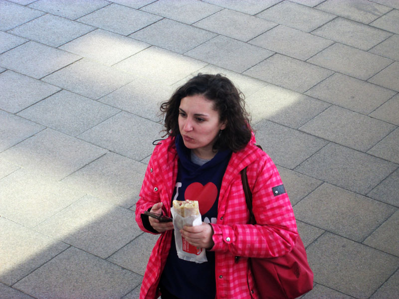 Девушка умудряется и говорить и есть.