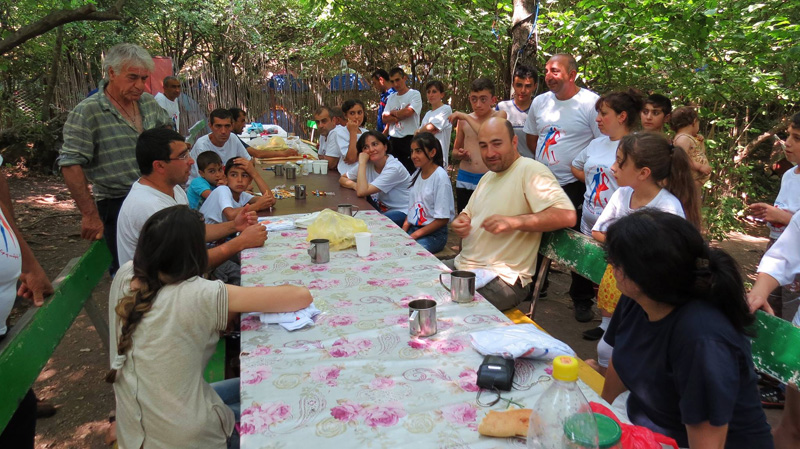 Священник Армен Ареян (справа на скамейке) говорит о Боге...
