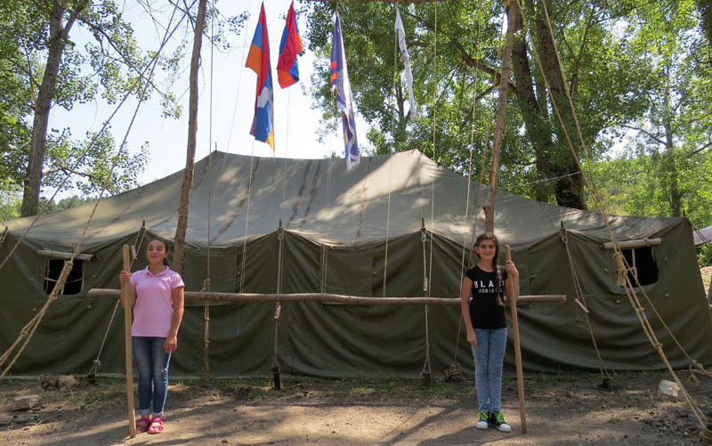 Далее, проходя по лагерю, увидел двух девочек Даниеллу (слева) и Анну, стоящих у знамён с «оружием» в руках. Поговорил с Даниеллой и узнал, что она перешла в 7 класс и ей тоже очень понравилось в лагере. «Мне очень нравится в лагере, хотя здесь и стр... Далее, проходя по лагерю, увидел двух девочек Даниеллу (слева) и Анну, стоящих у знамён с «оружием» в руках. Поговорил с Даниеллой и узнал, что она перешла в 7 класс и ей тоже очень понравилось в лагере. «Мне очень нравится в лагере, хотя здесь и строго. Но я понимаю, что это делается для нас, чтобы мы в дальнейшем могли стать самостоятельными. Здесь очень весело – танцы, песни, игры. Вчера моя мама приехала, чтобы забрать меня домой, но я отказалась, так как хочу остаться до конца лагеря. И ещё – я обзавелась новыми друзьями, чему очень рада...»